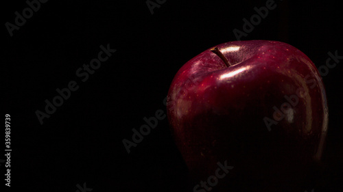 Foto artística de manzana roja jugosa y brillante sobre fondo negro