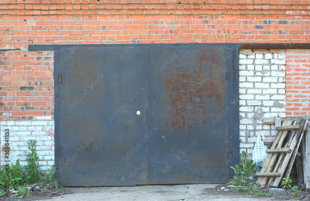 A large metal door in the wall of their red and white bricks A large metal door in the wall of their red and white bricks