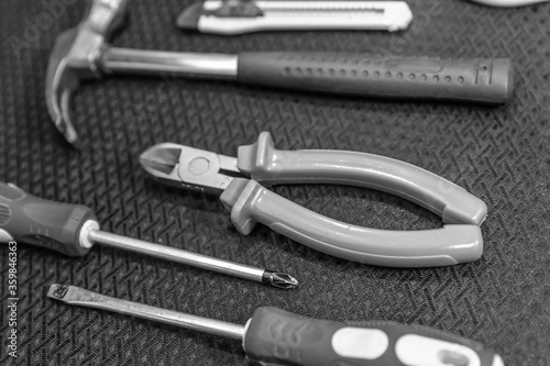 tool set tongs, hammer and a pair of tinted engineering screwdrivers close-up