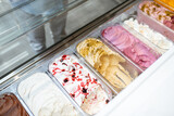 Close-up of ice cream with different flavors in the refrigerator on a shop window