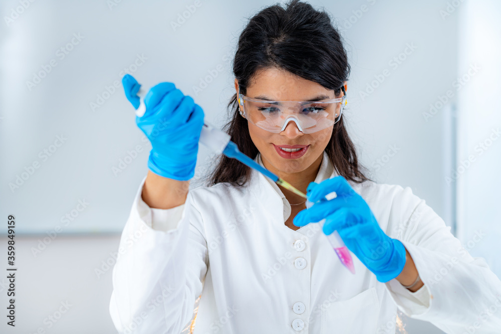 Student in White Coat, Working in Research Laboratory Using Micro Pipette and Test Tube