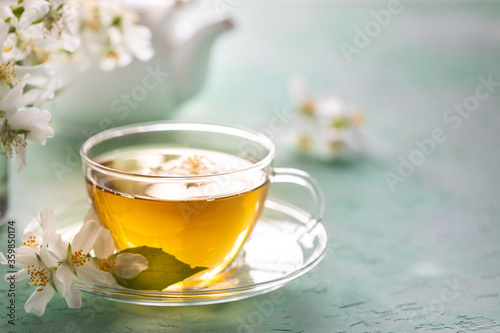 Jasmine flower tea on green stone, spa concept. Copy space