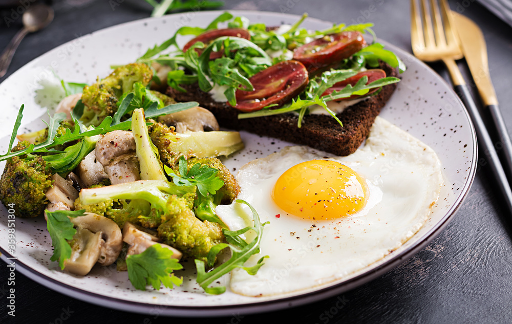 Breakfast with fried egg, broccoli, mushrooms and tomato sandwich. Healthy balanced food. Breakfast with fried egg, broccoli, mushrooms and tomato sandwich. Healthy balanced food.