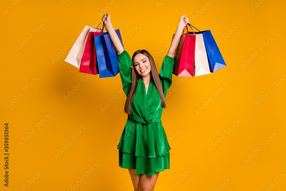 Portrait of her she nice-looking attractive cheerful cheery straight-haired girl carrying new things accessory clothes clothing isolated over bright vivid shine vibrant yellow color background