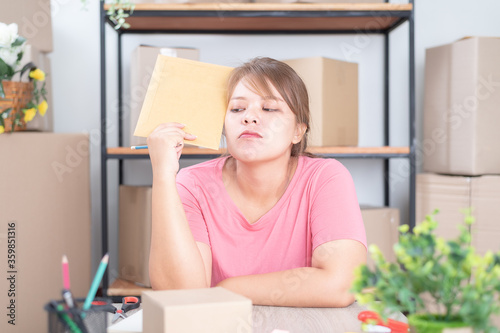 Selling online work from home. Women business owner working at home with packing box on the workplace - online shopping © LOVEis