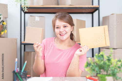 Selling online work from home. Women business owner working at home with packing box on the workplace - online shopping