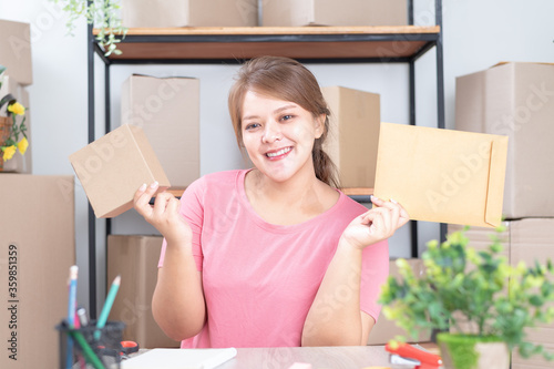 Selling online work from home. Women business owner working at home with packing box on the workplace - online shopping