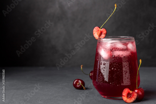 Cold cherry juice with ice on a dark background