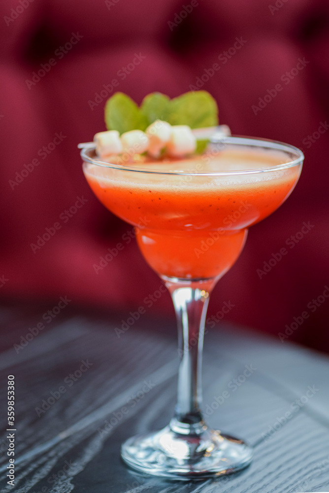 Cold summer alcohol cocktail with ice and fruit in a tall glass on light blurred restaurant or cafe background. Cold summer alcohol cocktail with ice and fruit in a tall glass on light blurred restaurant or cafe background.