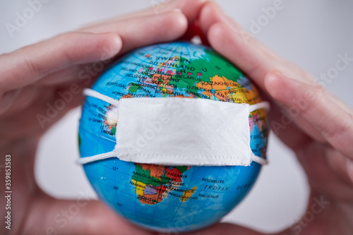 woman holding globe with protective mask