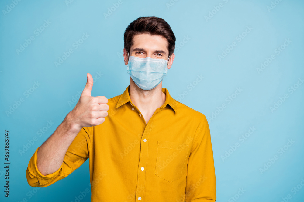 Close-up portrait of his he nice confident healthy guy wearing safety mask showing thumbup mers cov flu grippe prevention health care isolated pastel color background Close-up portrait of his he nice confident healthy guy wearing safety mask showing thumbup mers cov flu grippe prevention health care isolated pastel color background