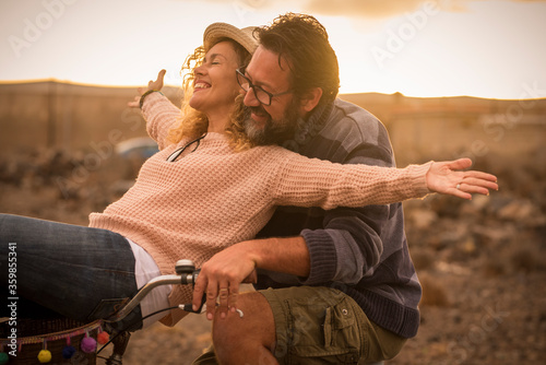 Fotografia, Obraz Happy adult people cheerful couple enjoy the outdoor leisure activity riding a b