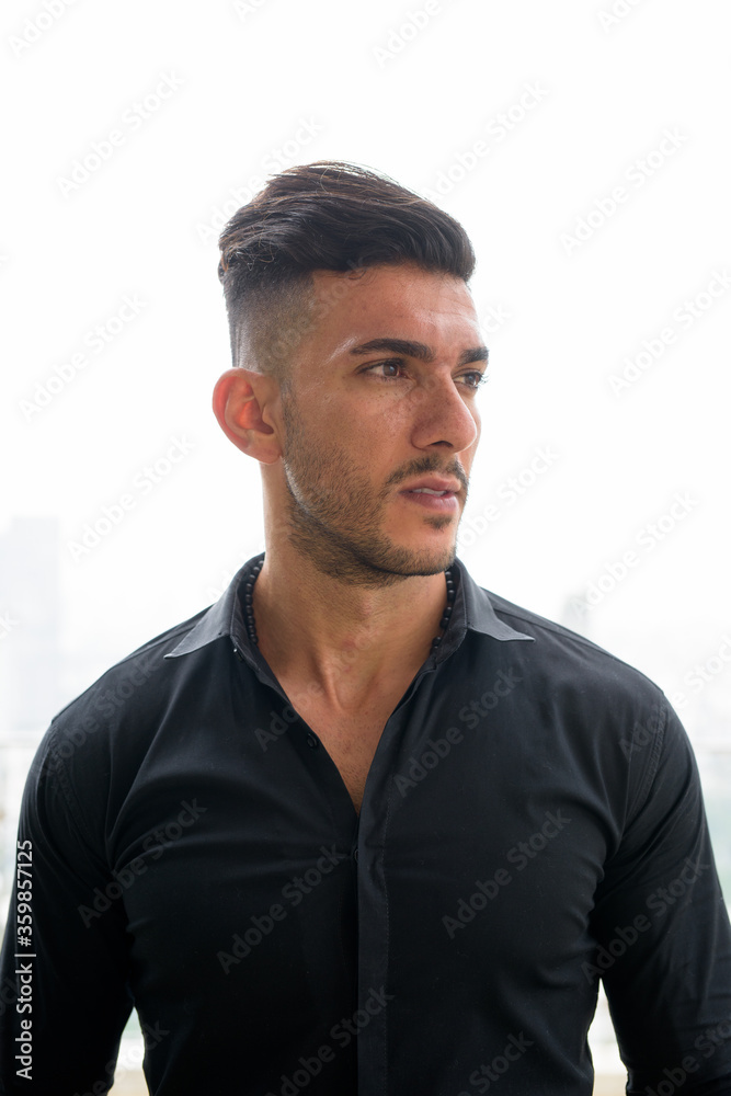 Young handsome bearded Persian businessman thinking in the city outdoors Young handsome bearded Persian businessman thinking in the city outdoors
