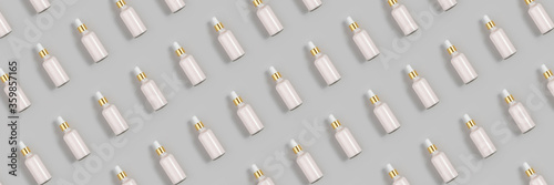 Cosmetic pattern. Banner made with pink anti-aging collagen, facial serum in transparent glass bottle with gold pipette on grey background. Natural Organic Spa Cosmetic Beauty Concept