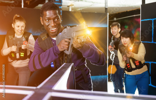 African man playing laser tag with friends