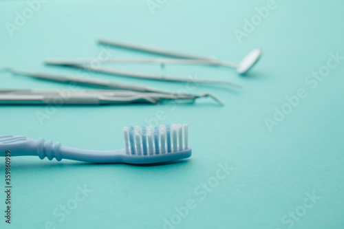 Dentist tools mirror  spatula  tweezers and toothbrush on a blue background.