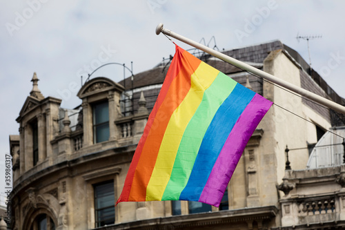Gay pride, LGBTQ rainbow flags being waved in the air at a pride event © ink drop