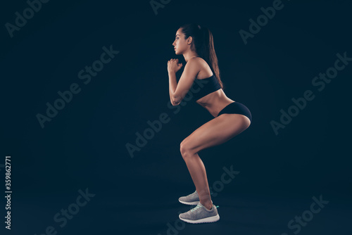 Full size profile photo short sport suit lady body weight workout sit ups improving ass muscles isolated black background