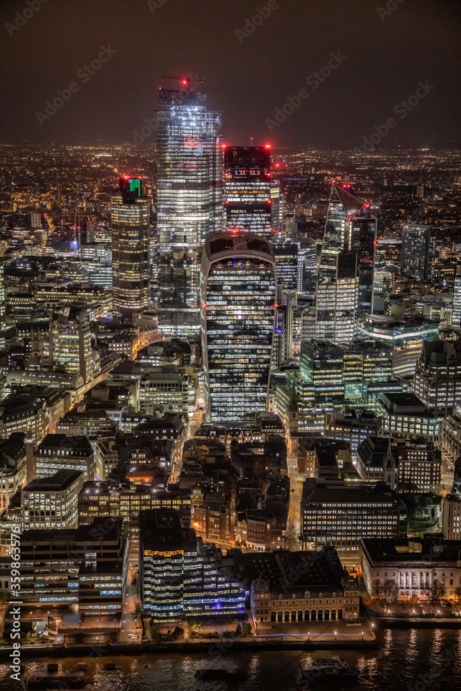 Obraz premium London city area skyline and buildings aerial photograph at night showing offices and office lights. Financial and banking district. 