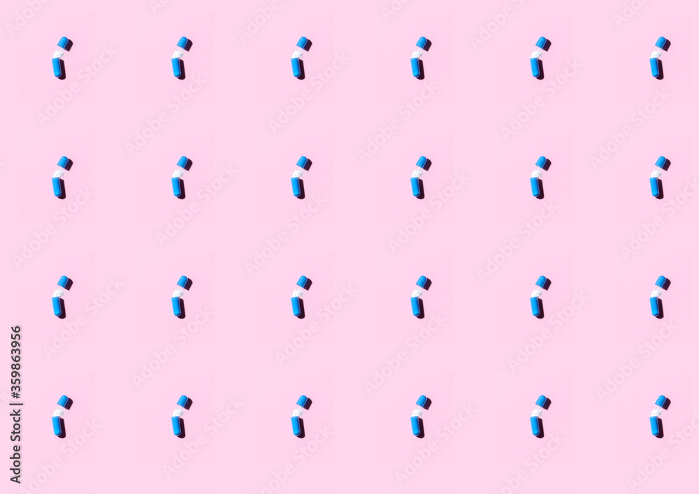 Blue pills an pill bottle on pink background. Blue pills an pill bottle on pink background.