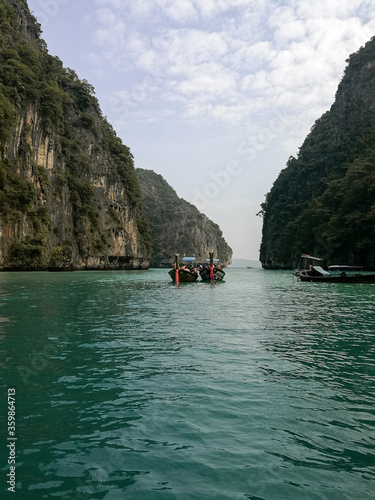 Relaxful sea holiday in Thailand, Phi-Phi island. Weekend with family at the Andaman sea. Travel by boat near the island. Waves and clouds near the sea. Image with selective focus, noise effect.