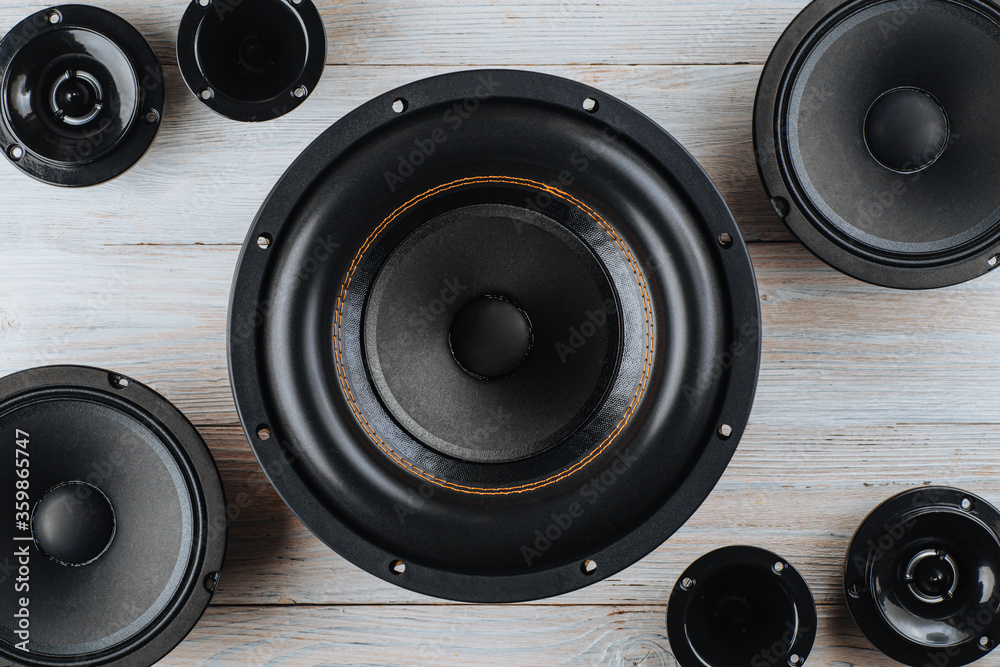 Car audio, car speakers, black subwoofer on a white wooden background. Close up Car audio, car speakers, black subwoofer on a white wooden background. Close up