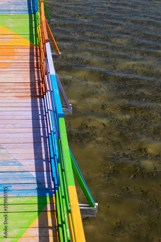 Wooden promenade decorated with vibrant and diverse colors, facing the sea and among the mangroves, in the city of Wakai, in the Togean Islands, Indonesia. photo