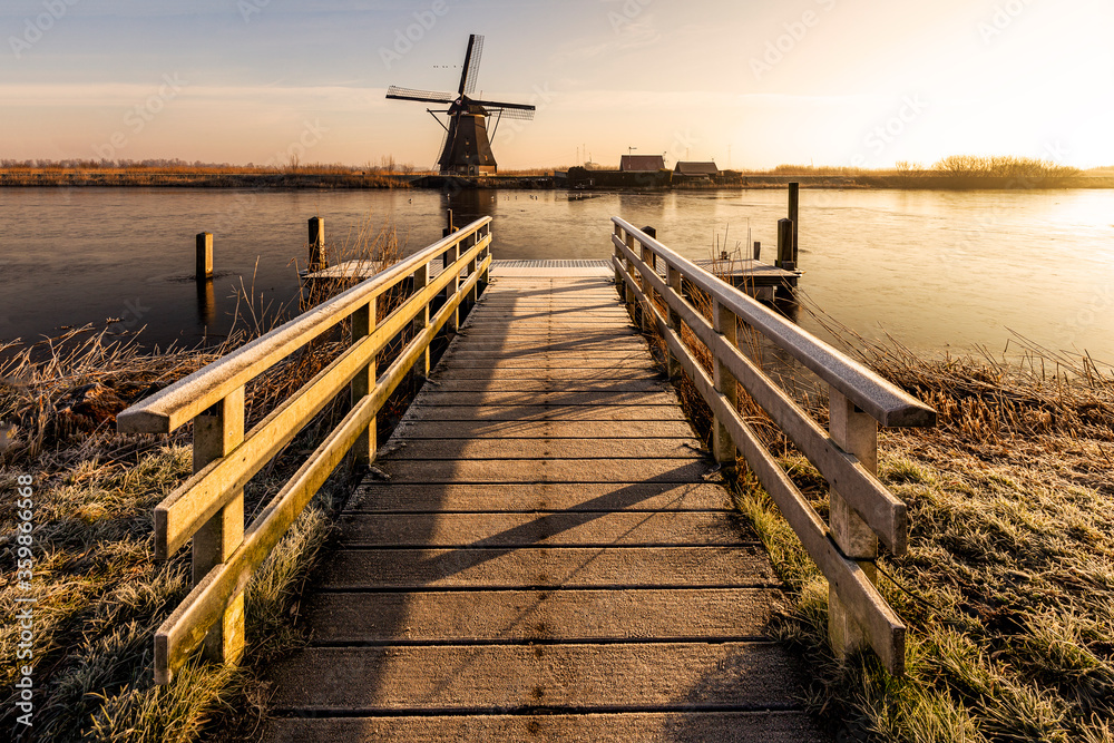 Boat platform in front of the Kinderdijk mill under the warm morning sun