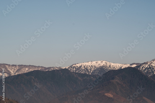 View of the foothills of the Caucasus. High peaks are covered with snow. Mountains against the blue sky. Day. Sunny. Georgia. © Viktor