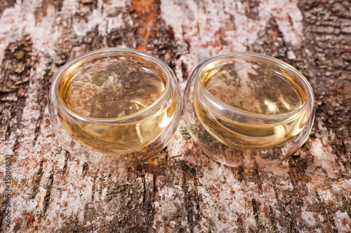 Bai Mu Dan (White Peony) white tea in the transparent cups on the birch bark background photo