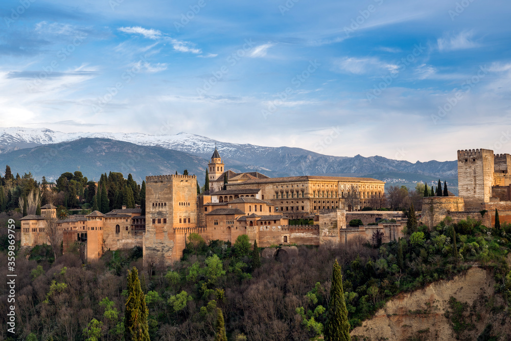 El palacio de La Alhambra y sus murallas rodeadas de vegetacion y colores primaverales en la colina de la Sabika, Granada, Andalucia, España