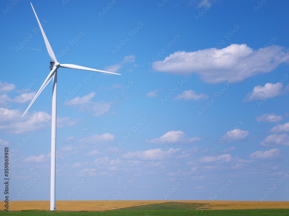 Obraz premium Wind turbine in the field and blue sky