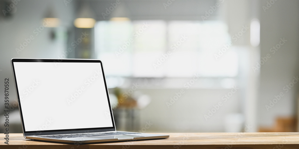 Computer laptop is putting on a wooden plank over the living room as a background. Computer laptop is putting on a wooden plank over the living room as a background.