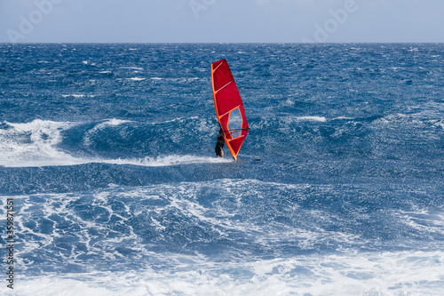 Windsurfing sails on the blue sea