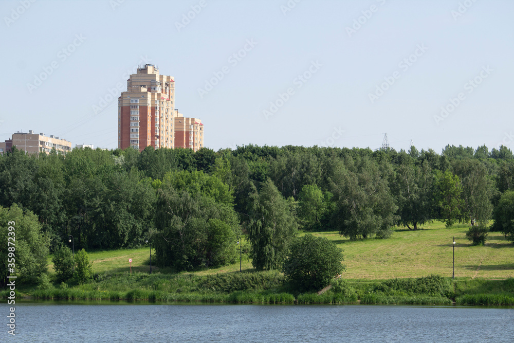 Multistorey building in the park on the bank of the river