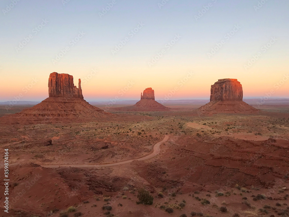 Amazing view of Monument Valley with red desert and blue sky and clouds in the morning. Monument Valley in Arizona with West Mitten Butte, East Mitten Butte, and Merrick Butte. Amazing view of Monument Valley with red desert and blue sky and clouds in the morning. Monument Valley in Arizona with West Mitten Butte, East Mitten Butte, and Merrick Butte.