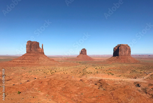 Amazing view of Monument Valley with red desert and blue sky and clouds in the morning. Monument Valley in Arizona with West Mitten Butte, East Mitten Butte, and Merrick Butte. 