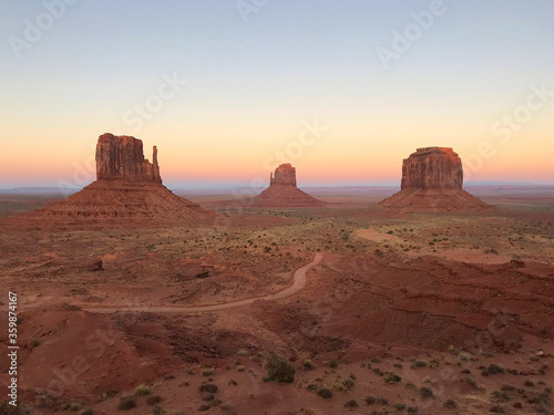 Amazing view of Monument Valley with red desert and blue sky and clouds in the morning. Monument Valley in Arizona with West Mitten Butte  East Mitten Butte  and Merrick Butte. 