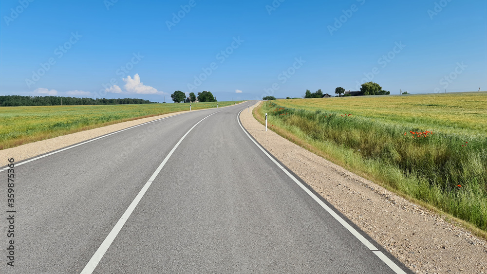 Asphalt road between agricultural fields of Latvia