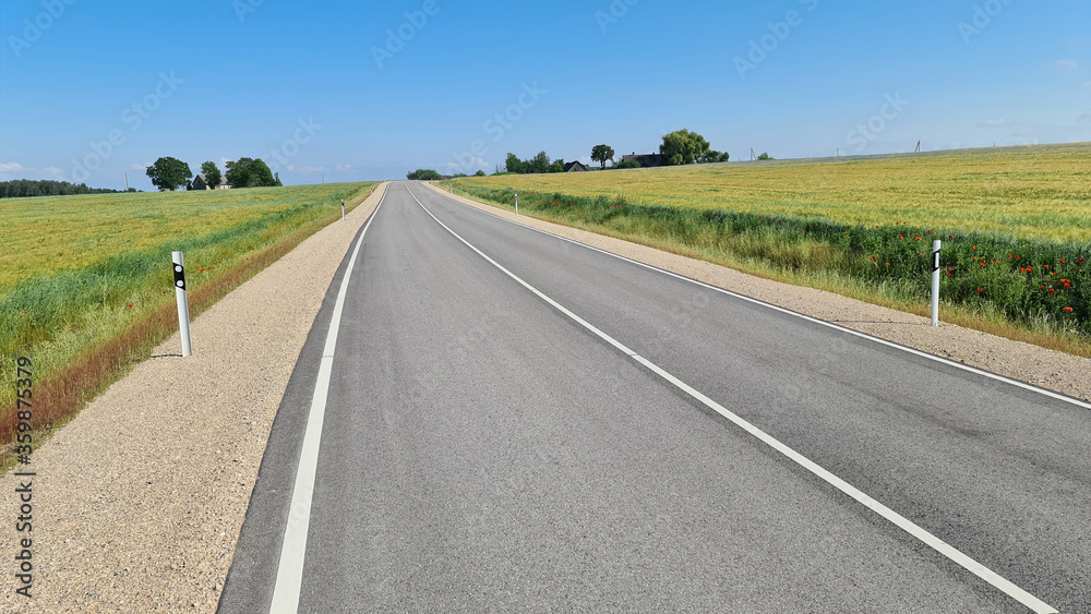 Asphalt road between agricultural fields of Latvia Asphalt road between agricultural fields of Latvia