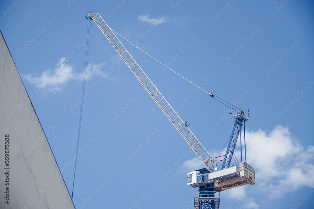 Very high construction crane with blue sky in the background