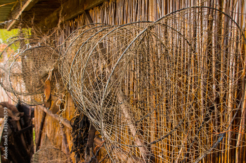 Fishing tackles hang on a reed wall photo