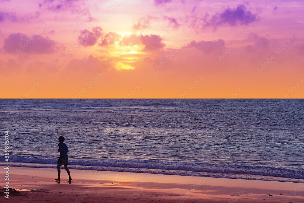 silhouette jogging on the beach with sunset sweet twilight sky colour in Phuket Thailand