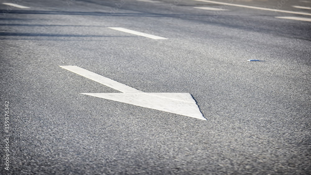 White arrow on asphalt road surface, transportation concept and keep moving idea White arrow on asphalt road surface, transportation concept and keep moving idea
