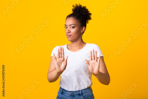 Serious black girl showing stop sign with two hands
