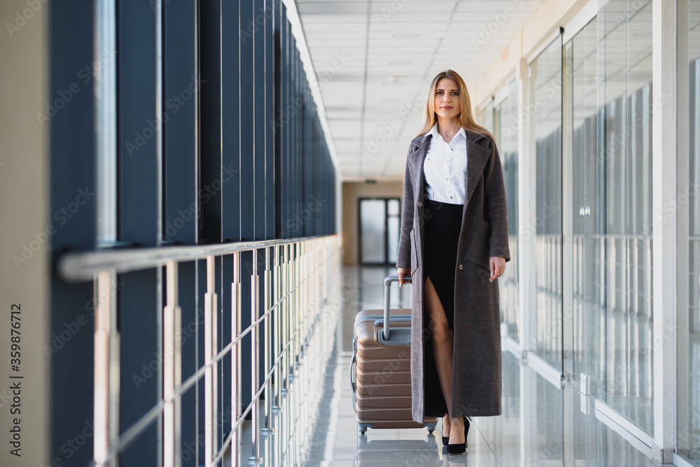 Portrait of successful business woman traveling with case at airport. Beautiful stylish female travel with luggage. Portrait of successful business woman traveling with case at airport. Beautiful stylish female travel with luggage.