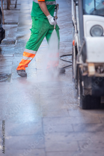 Person cleaning streets with a pressure gun