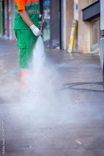 Person cleaning streets with a pressure gun