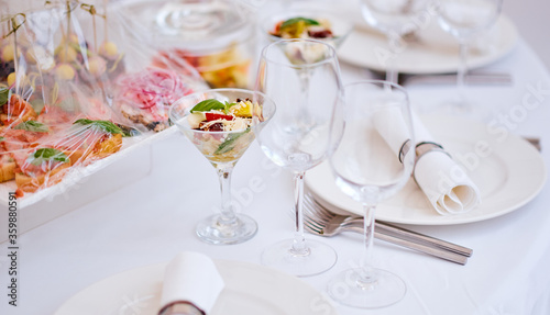 Beautiful festive table of luxury plates, glasses and cutlery served for wine tasting. Close up, blur background. © Антон Ильченко