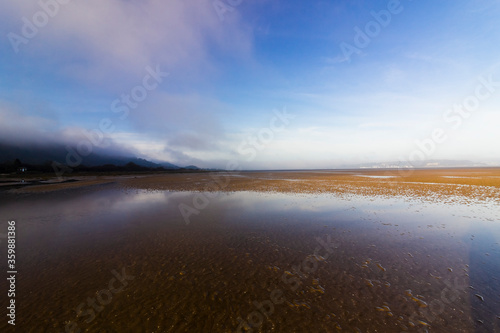 Coastal view from Red Wharf Bay of the early morning mist dispersing overhead  Isle of Anglesey  North Wales